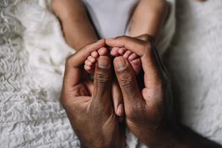 father hand with baby feet