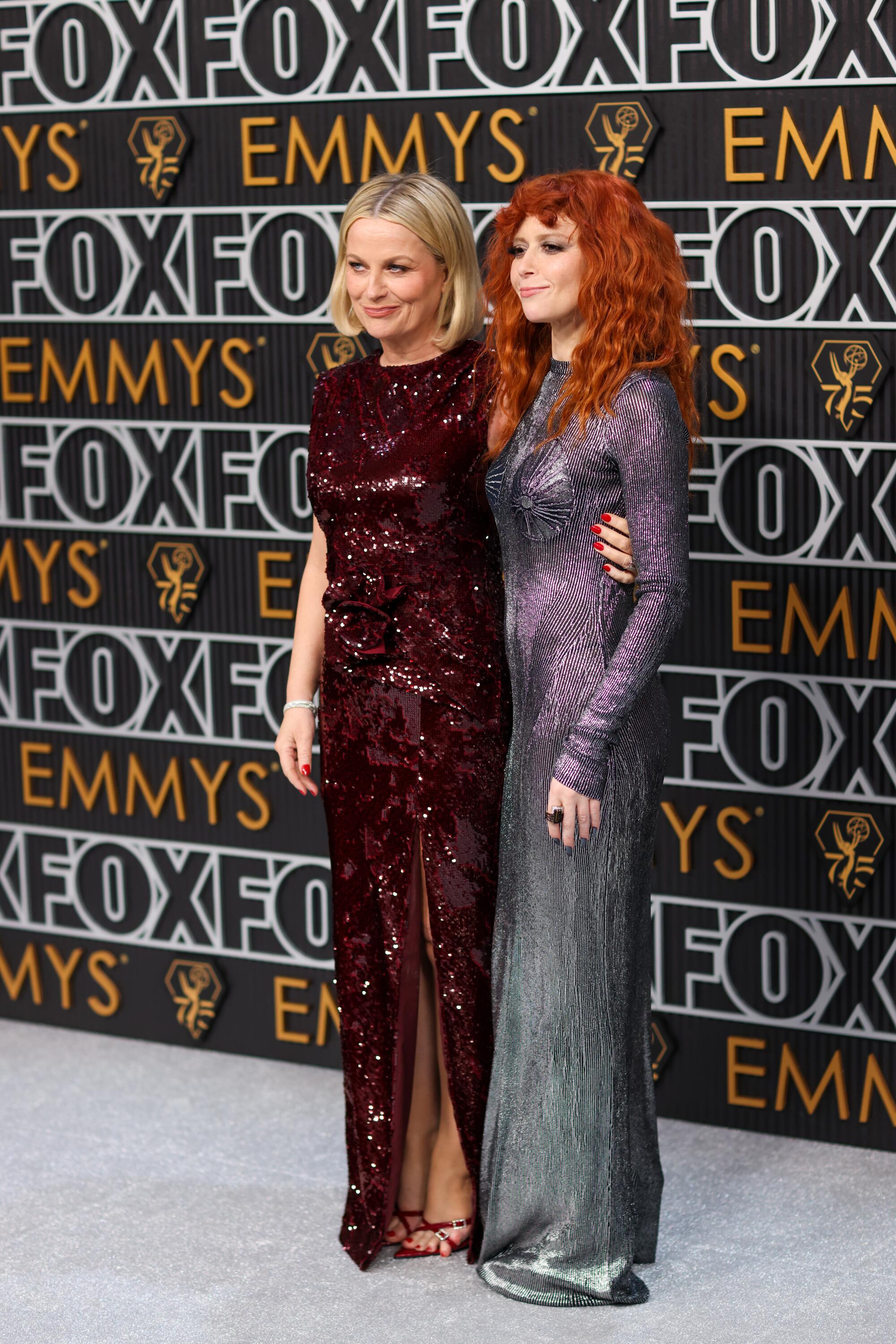 Amy Poehler and Natasha Lyonne pose on the Emmys red carpet. 