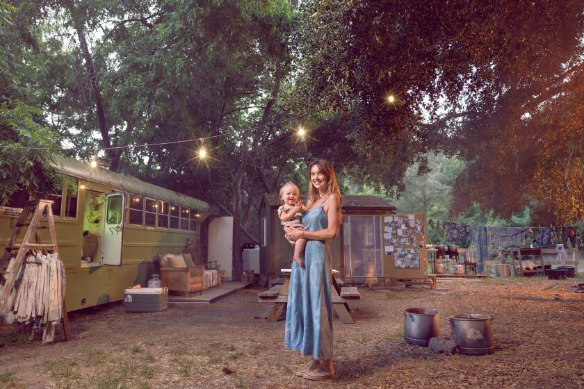 Ojai, CA - June 10: Laura LaRue at home with her 16-month-old daughter Lasca on Monday, June 10, 2024 in Ojai, CA. Laura, 32, is a single-mom and former model raising her daughter in a former school bus. She went from living in a cabin on her mom's ranch to an off-grid trailer in Carpinteria, to a school bus with a newborn baby. During the pandemic, she started her natural tie dye business, Ride or Dye Ojai. "It's very chill and it's not that crazy at all," she says of the baby-proofed bus. "It's baby heaven." (Ryan Schude / For The Times)