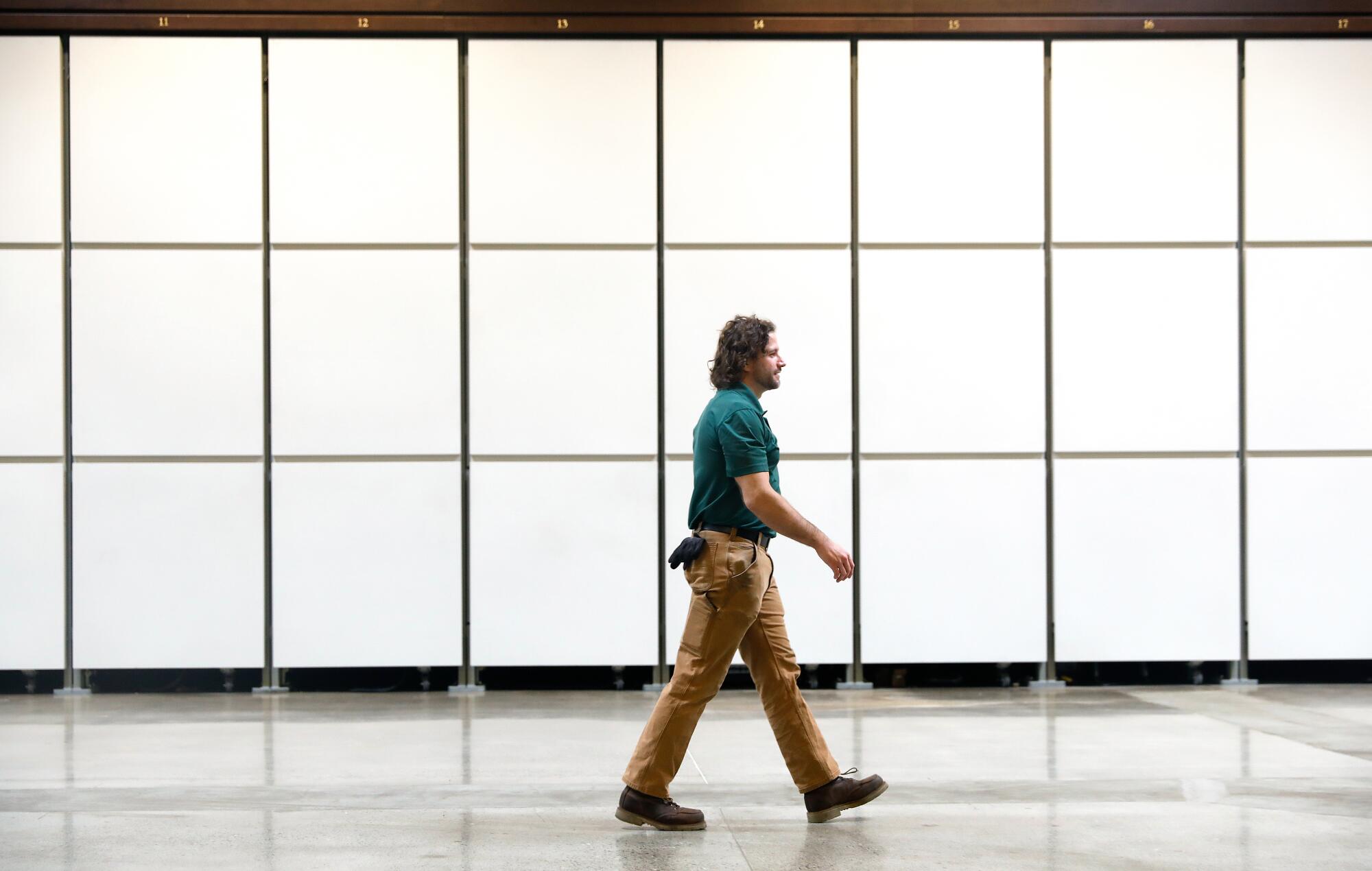 John Lawrence walks past rows of spaces for vessels.