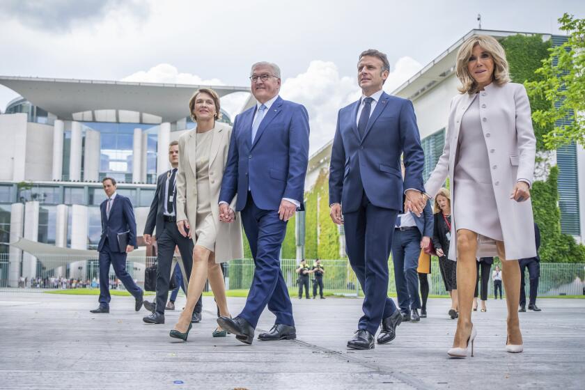 French President Emmanuel Macron and his wife Brigitte, right, walk with German President Frank-Walter Steinmeier his wife Elke Büdenbender as they arrive to attend the democracy festival to mark the 75th anniversary, near Berlin, during Macron's three-day state visit to Germany, Sunday, May 26, 2024. (Kay Nietfeld/dpa via AP)