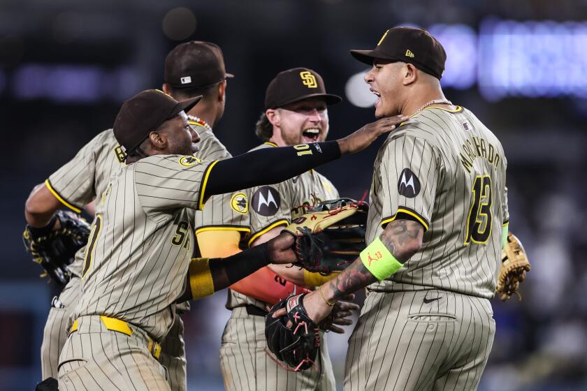 Los Angeles, CA, Tuesday, September 24, 2024 - San Diego Padres third base Manny Machado (13) is swarmed by teammates after starting a game ending triple play to preserve a 4-2 win over the Dodgers at Dodger Stadium. (Robert Gauthier/Los Angeles Times)