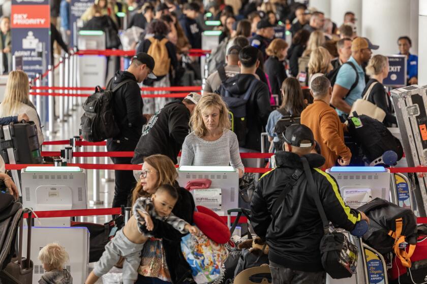 LOS ANGELES, CA - MAY 23: Travelers get boarding passes and check in baggage at the Delta Airlines terminal at Los Angeles International Airport on Thursday, May 23, 2024. Airport officials are urging people to plan ahead and give themselves plenty of time to reach the airport and board their flights. Memorial Day traditionally marks the beginning of the summer travel season and airport officials said passenger numbers and vehicular traffic will be rising over the next few days and remain high for the next few months. (Myung J. Chun / Los Angeles Times)