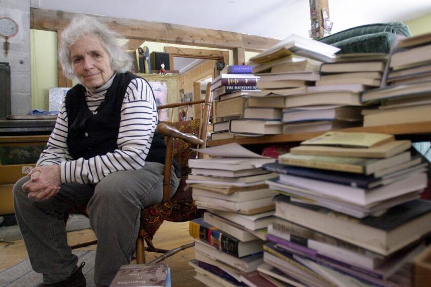 **FILE**Author Grace Paley sits beside a pile of books in her home in Thetford Hill, Vt., April 9, 2003. Paley, who had battled breast cancer, died Wednesday, Aug. 22, 2007 at her home in Thetford Hill, Vt., according to her husband, playwright Robert Nichols .She was 84. (AP Photo/Toby Talbot)
