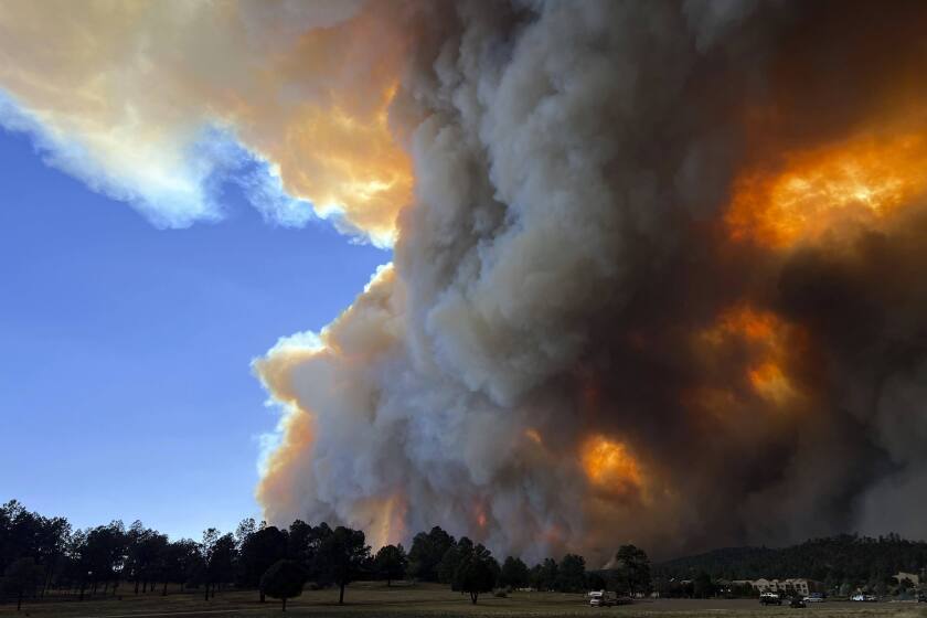 In this photo provided by Pam Bonner, smoke rises from fires in Ruidoso, N.M., Monday, June 17, 2024. Thousands of southern New Mexico residents fled the mountainous village as a wind-whipped wildfire tore through homes and other buildings. (Pam Bonner via AP)