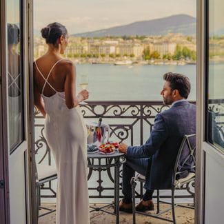 A couple sips champagne on a hotel balcony