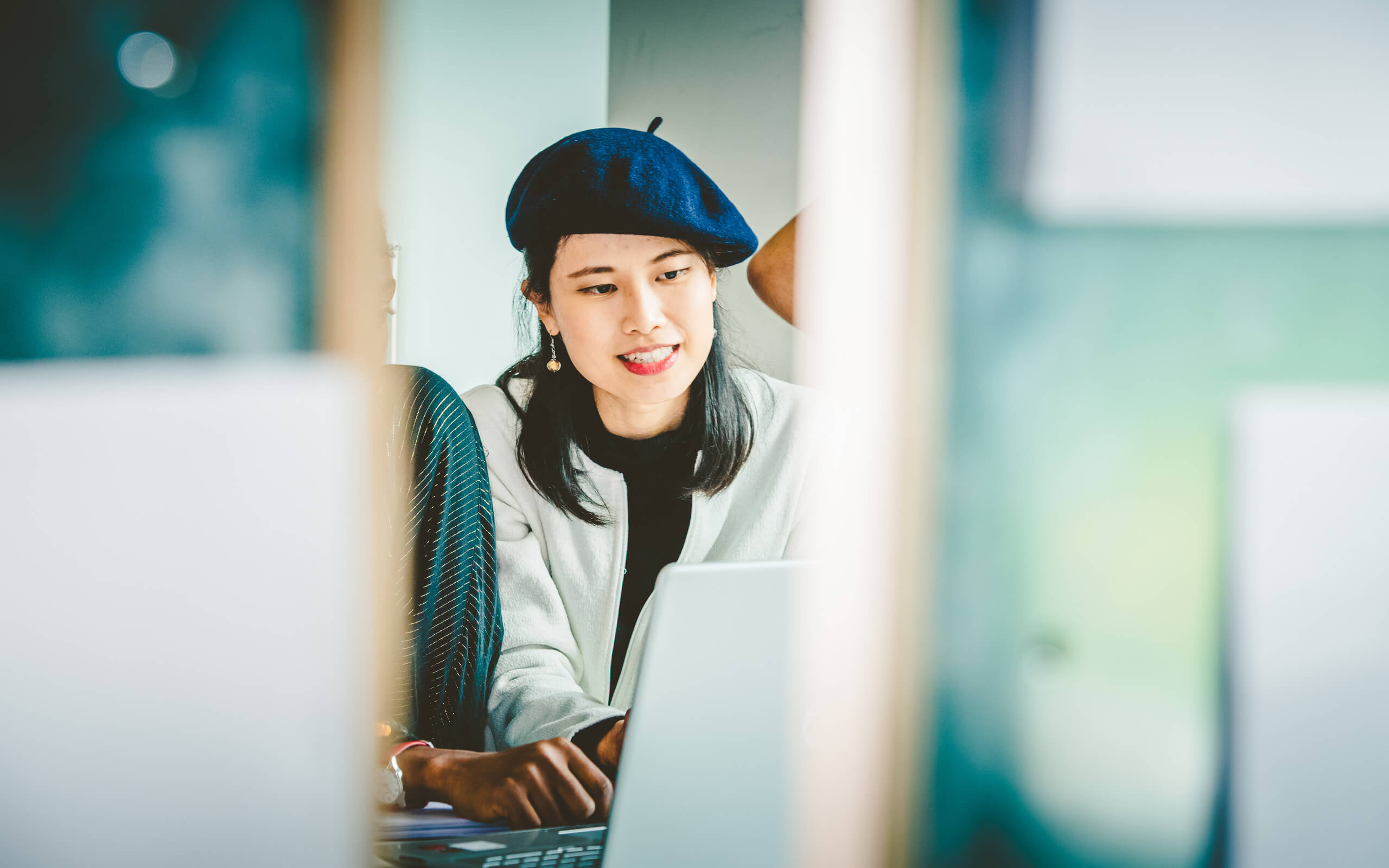 Bua, a female student from Thailand sitting wearing a blue beret