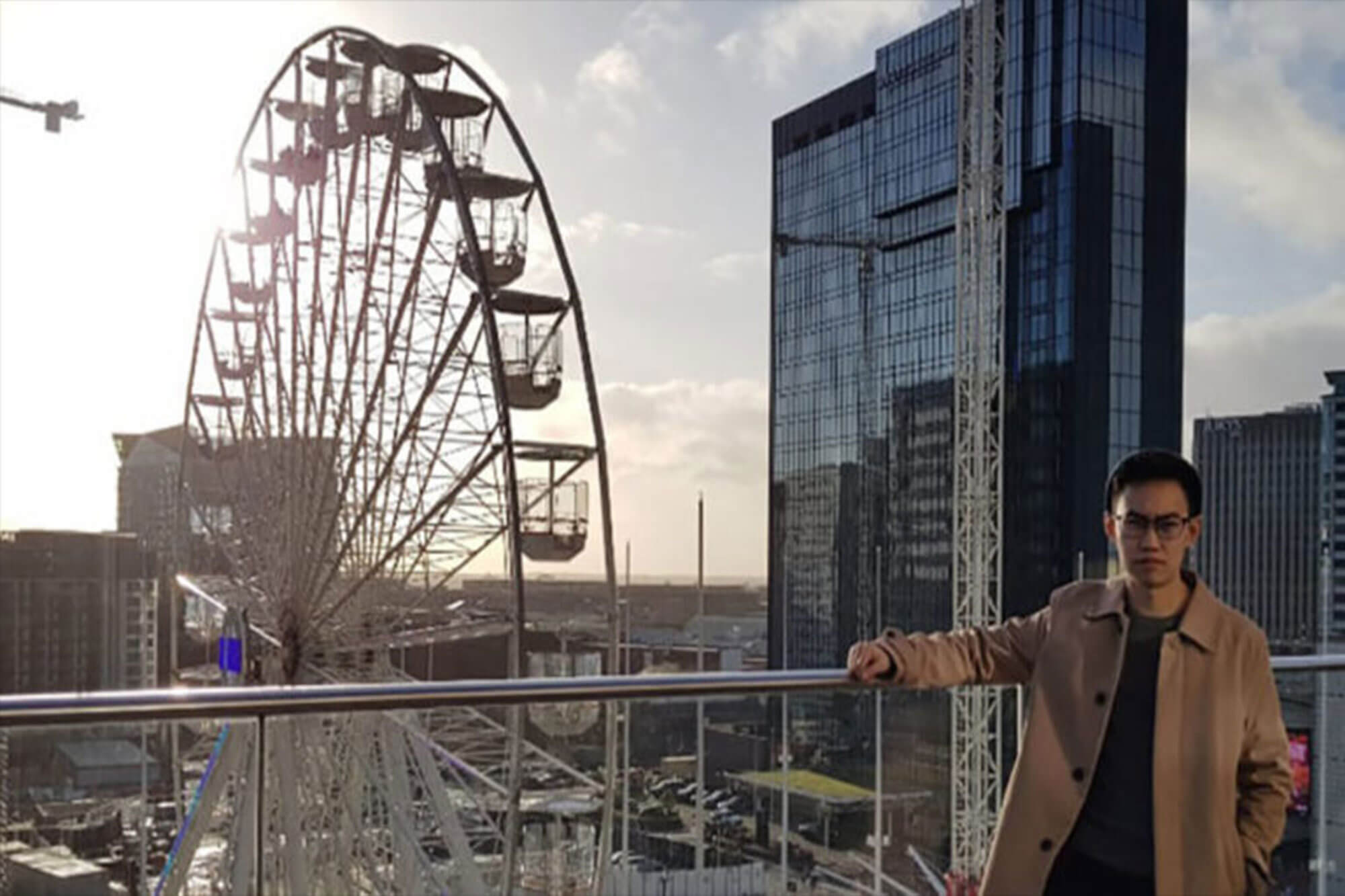 International student in a city centre with Ferris wheel in the background