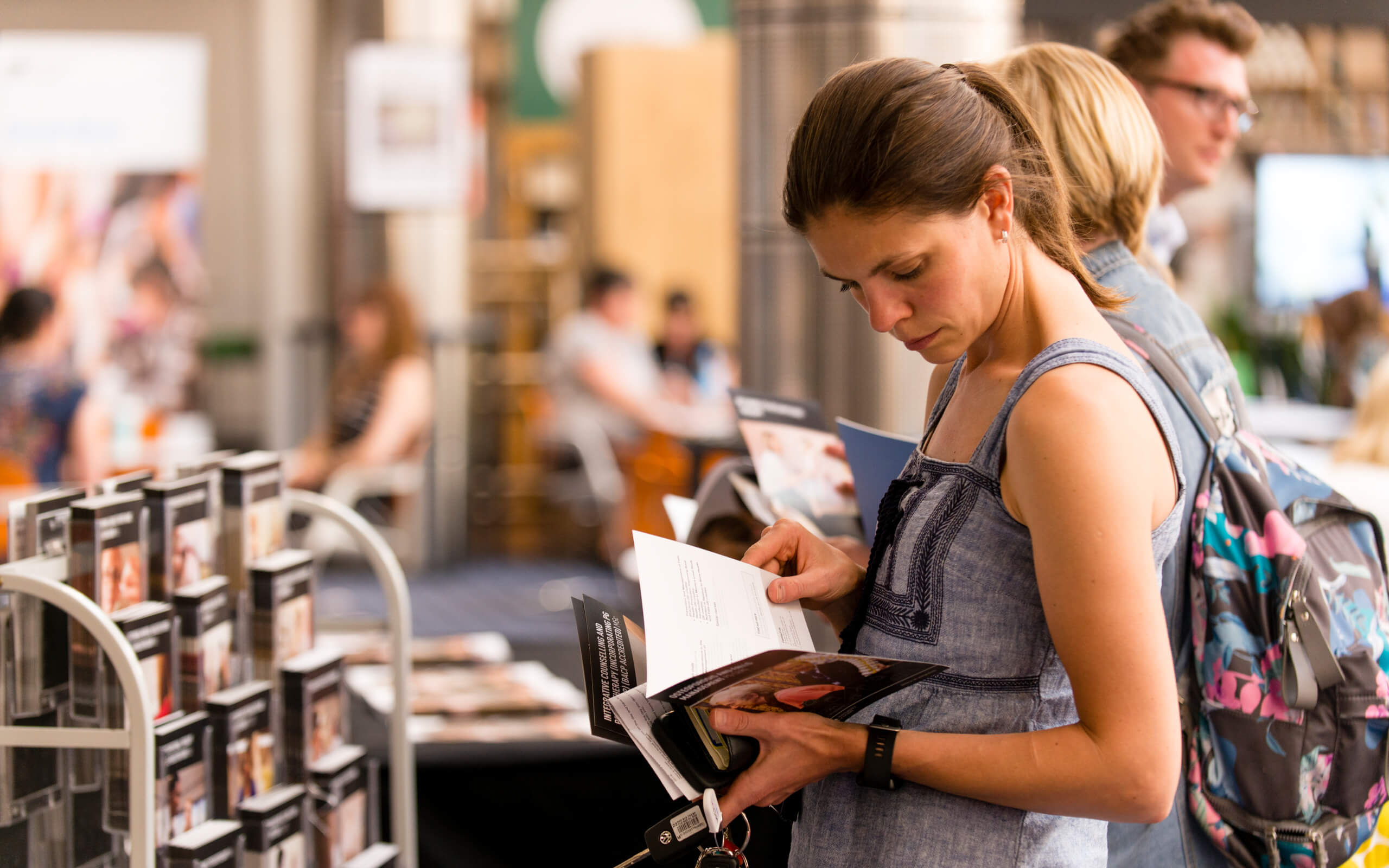 Woman looking through leaflet at Postgraduate Open Evening