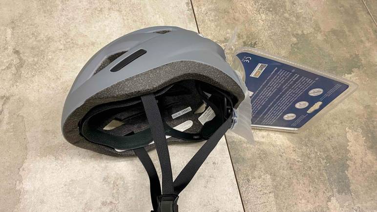 Im Test: Ein Abus-Fahrradhelm von der Seite auf einer Steinfläche liegend.