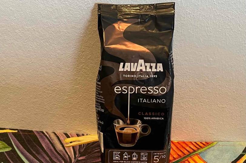 Lavazza-Kaffeebohnen getestet: Eine Packung steht auf einer bunten Tischdecke vor einer hellen Wand.