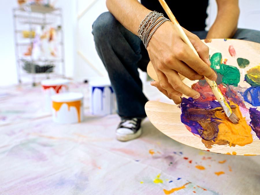 Close-up of a palette held by a man. Mixing paint, painting, color mixing.