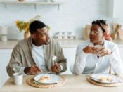 Ein Mann und eine Frau essen an einem Tisch – Intervallfasten ist für beide Geschlechter nicht gleich gut geeignet.