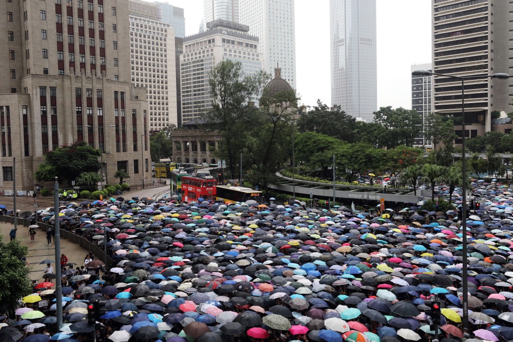 Umbrellas go up in Central as thousands of teachers brave heavy rain to show solidarity with their students. Photo: Dickson Lee