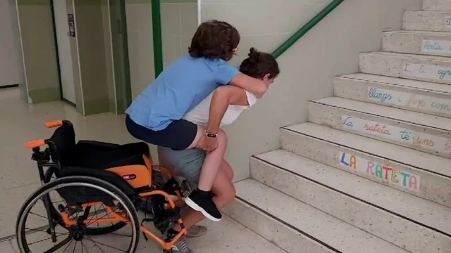 Una madre vuelve a subir a cuestas a su hijo con movilidad reducida porque el ascensor de su colegio de Alicante sigue averiado