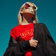 Model with sunglasses on and flower in her mouth