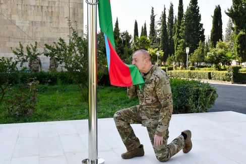 Präsident Alijew küsst in der zurückeroberten Region Bergkarabach die Flagge seines Landes