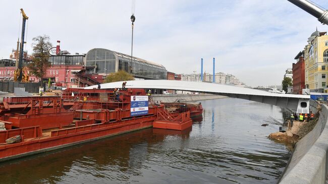 Рабочие во время завершения работ над мостом, установленным между островом Балчуг и Парком Горького в Москве