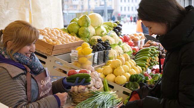 Продавец и покупательница на ярмарке. Архивное фото