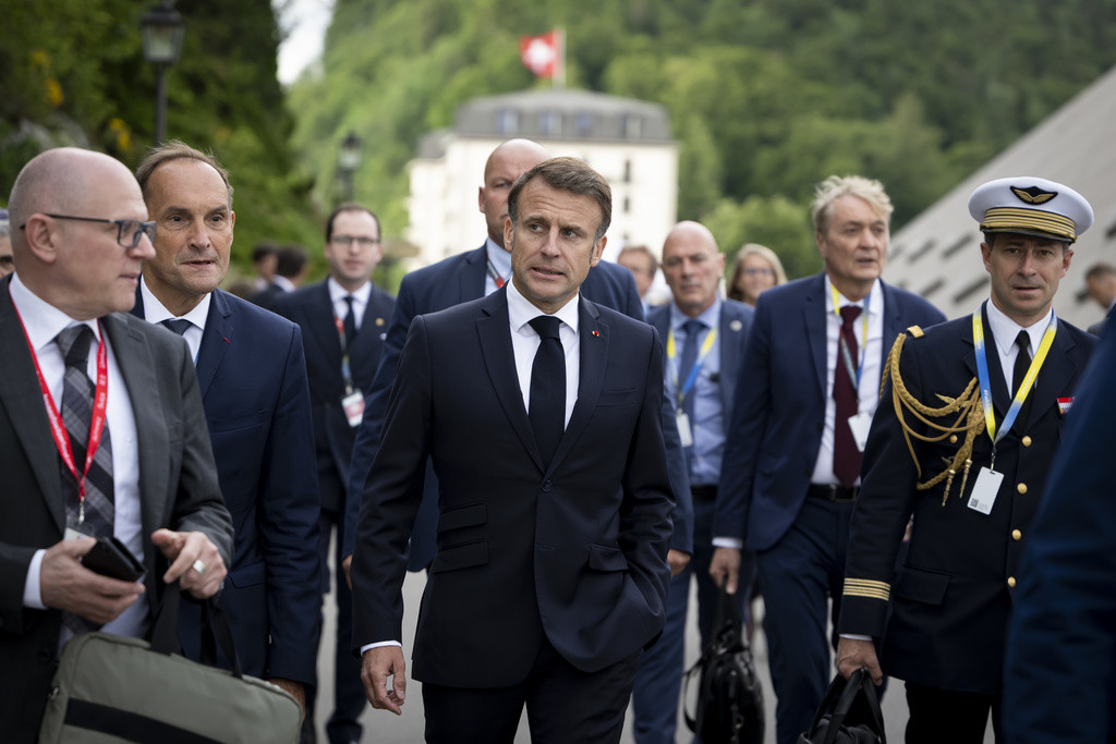 President Emmanuel Macron of France, center, arrives with her delegation at the Summit on peace in Ukraine, in Stansstad near Lucerne, Switzerland, Saturday, June 15, 2024. Heads of state from around the world gather on the Buergenstock Resort in central Switzerland for the Summit on Peace in Ukraine, on June 15 and 16. (KEYSTONE/EDA/POOL/Alessandro della Valle)