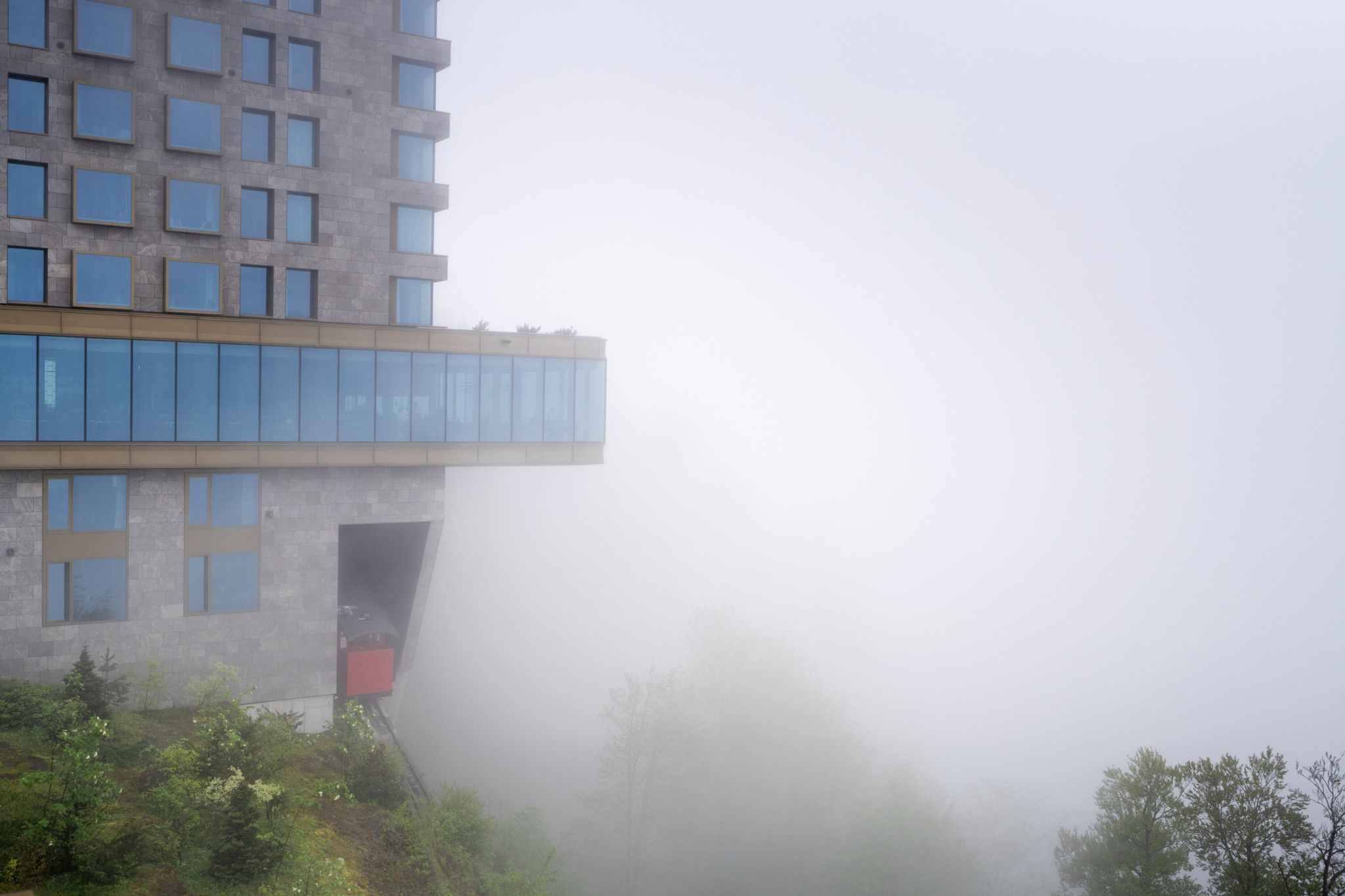 Die Buergenstock-Standseilbahn kommt bei Regen und Nebel in der Bergstation im Hotel Buergenstock an, fotografiert am Dienstag, 7. Mai 2024 in Obbuergen. (KEYSTONE/Gaetan bally)