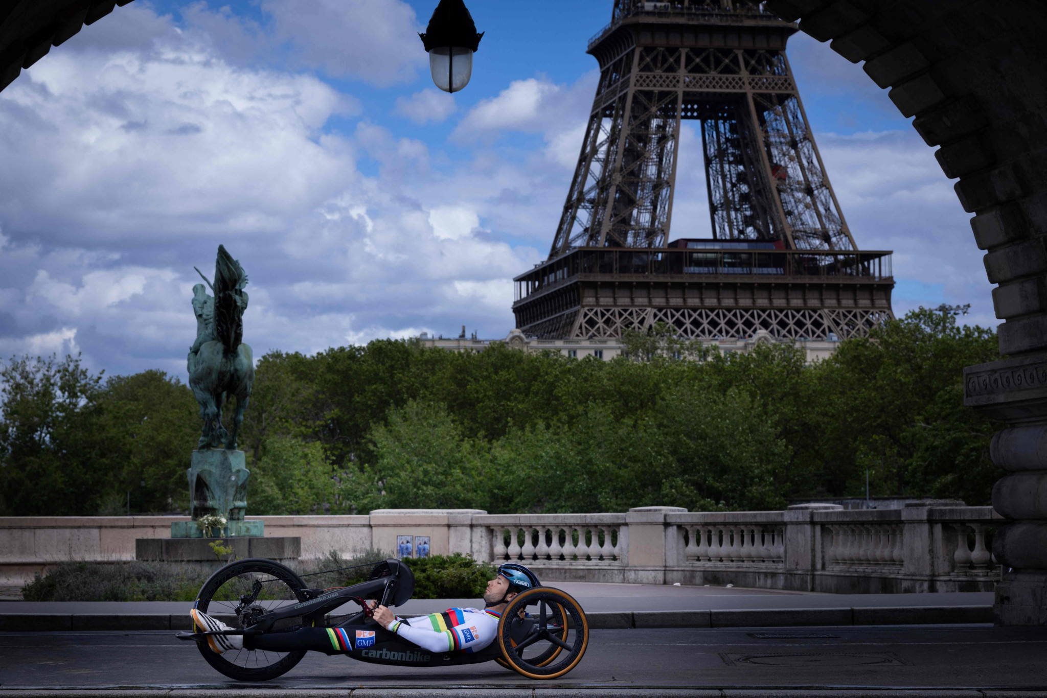 TOPSHOT - France's paralympian cyclist Florian Jouanny poses at The Bir-Hakeim Bridge in Paris on May 6, 2024, ahead of Paris 2024 Olympic and Paralympic games. The Bir-Hakeim bridge is a two-level bridge built in the early 20th century, registered as a historical monument by decree of July 10, 1986. (Photo by Joël SAGET / AFP) / RESTRICTED TO EDITORIAL USE