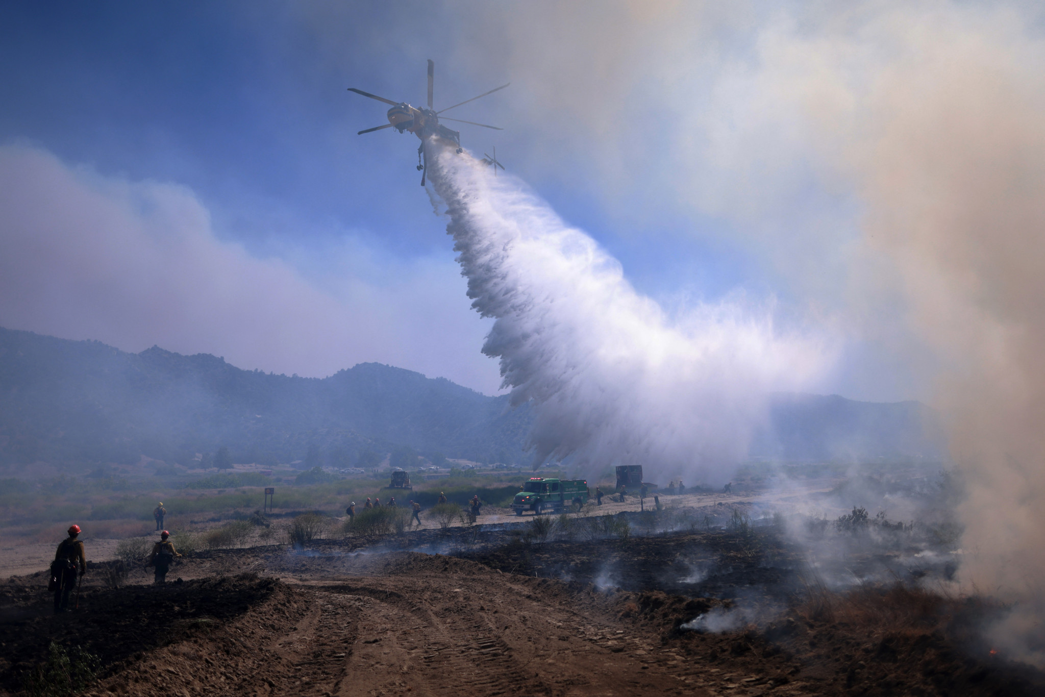 Air support drops water as the Post Fire burns through Castaic, California, June 16, 2024. The fire has grown to 12,265 acres, and continues to move southeast of Pyramid Lake, according to the US Department of Agriculture Forest Service at Angeles National Forest. (Photo by David SWANSON / AFP)