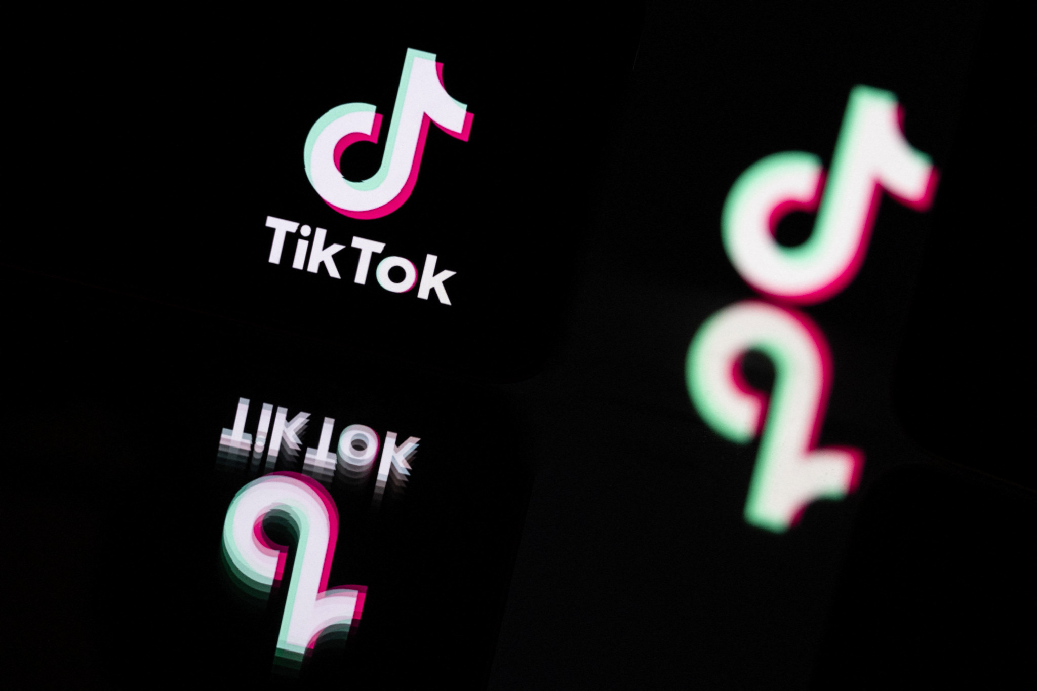 This photograph taken in Mulhouse, eastern France on October 19, 2023, shows the logo of the social media video sharing app Tik Tok reflected in mirrors. (Photo by SEBASTIEN BOZON / AFP)