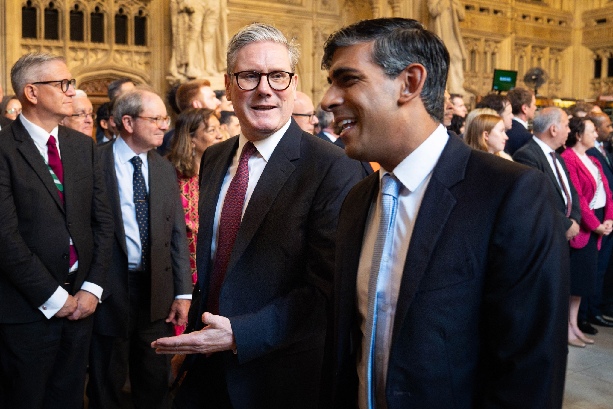 Britain's Prime Minister Keir Starmer (L) and Britain's Conservative Party opposition leader Rishi Sunak (R) speak together as they process through the Central Lobby during the State Opening of Parliament at the Houses of Parliament, in London, on July 17, 2024. (Photo by Stefan Rousseau / POOL / AFP)