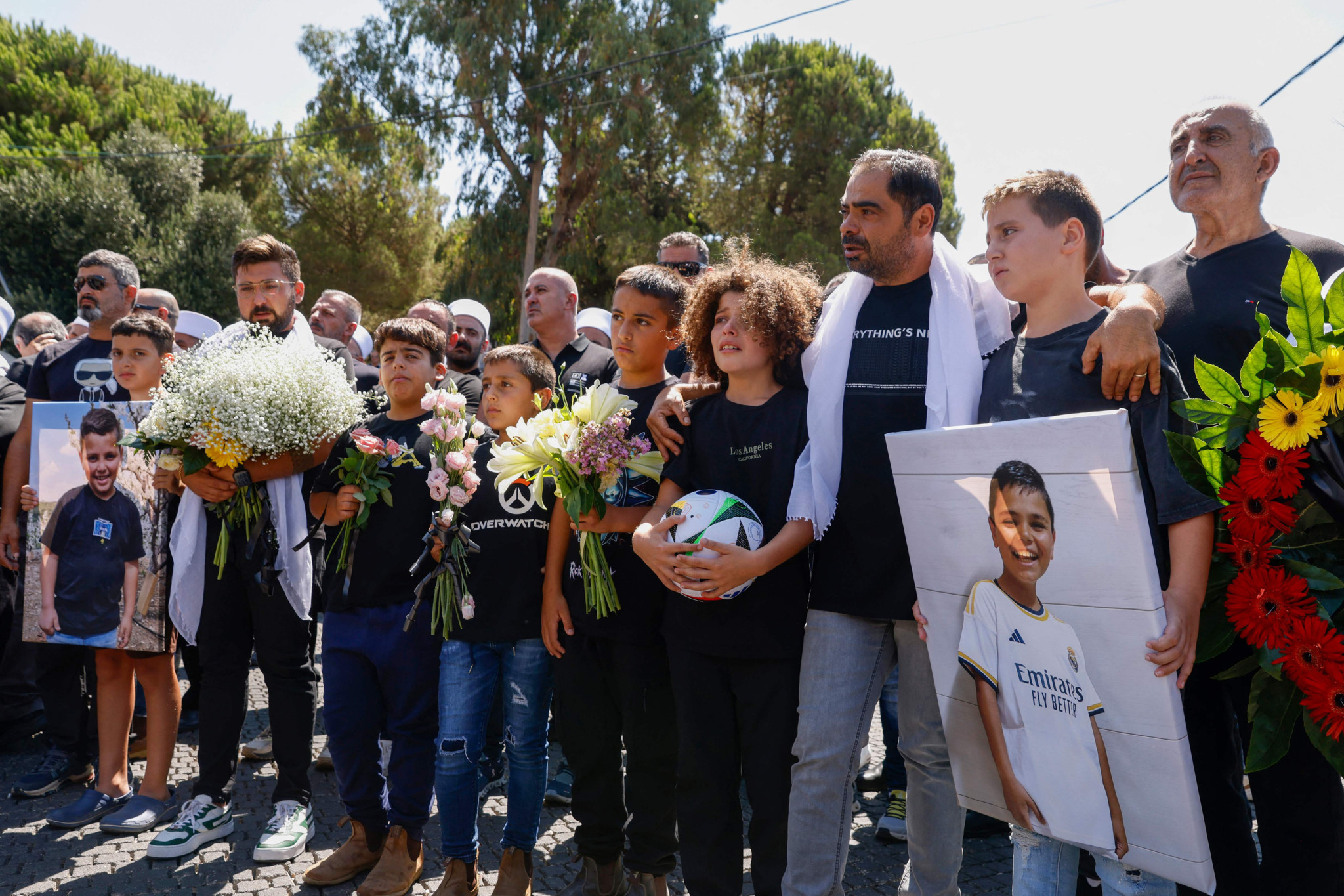 Mourners comfort each other during the funeral of Guevara Ibrahim, 11, killed in a reported strike from Lebanon two days earlier, in the Druze town of Majdal Shams in the Israeli-annexed Golan on July 29, 2024. Ibrahim was initially reported missing but has later been confirmed dead, while 11 others killed were laid to rest on July 28 in the Druze Arab town, hit a day earlier in a strike blamed by Israel on Lebanon's Hezbollah group that denied responsibility, though it claimed attacks on Israeli military positions that day. (Photo by Jalaa MAREY / AFP)