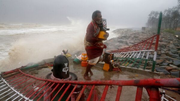 A Hindu priest carries an idol of Lord Jagannath from a seafront temple to a safer place ahead of Cyclone Yaas in Balasore district in the eastern state of Odisha India, May 26, 2021 - Sputnik International