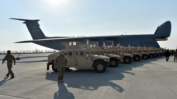 Ukrainian servicemen walk in front of US-made armoured cars at Kiev airport. File photo - Sputnik International