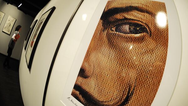 A woman walks past works by Spanish artist Salvador Dali. file photo - Sputnik International