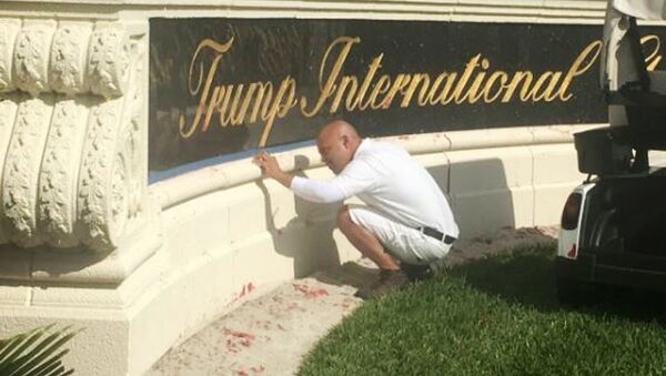 A worker cleans up red paint from the stone sign at the entrance to the Trump International Golf Club in West Palm Beach, Fla., Sunday, April 1, 2018. - Sputnik International