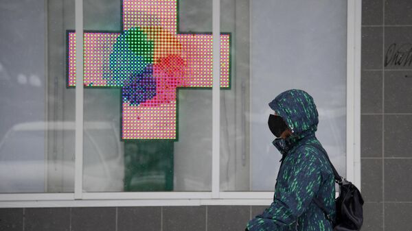 Прохожий в медицинской маске около аптеки в городе Щелково Московской области