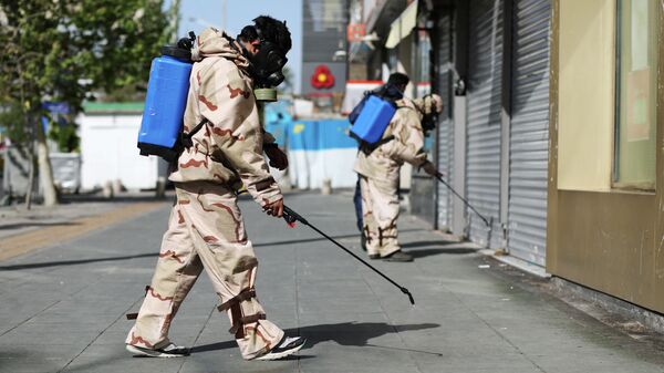 Волонтеры в защитных костюмах дезинфицируют улицы в Тегеране, Иран