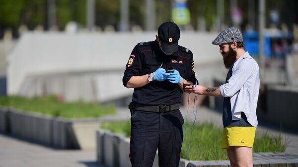 Сотрудник полиции проверяет документы у мужчины на роликах на Москворецкой набережной в Москве