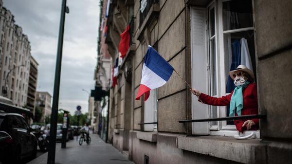 Женщина держит флаг Франции во время акции в поддержку врачей в пригороде Парижа