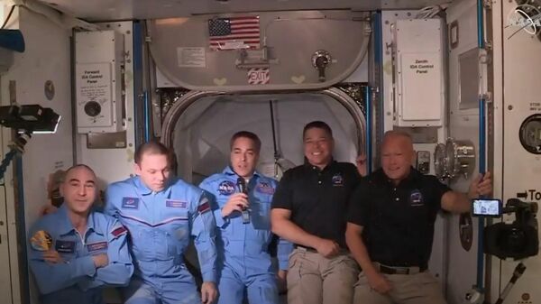 Экипаж принадлежащего SpaceX корабля Crew Dragon перешел на Международную космическую станцию. Стоп-кадр трансляции