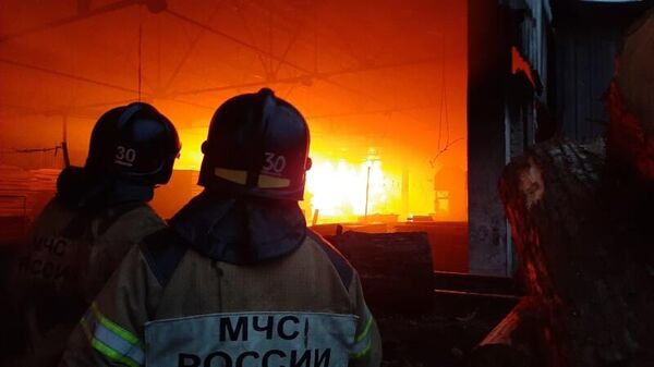 Сотрудник МЧС во время тушения пожара в складском помещении