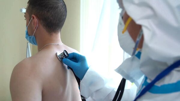 Врач проводит ежедневный обход-осмотр участника испытаний вакцины от коронавируса в Главном военном клиническом госпитале имени Н. Н. Бурденко в Москве