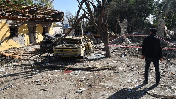 Люди на месте кафе, разрушенного в результате обстрела у города Барда