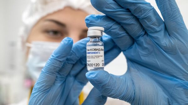 Медработник демонстрирует компонент 1 вакцины от коронавируса Спутник V в прививочном пункте городской поликлиники No 191