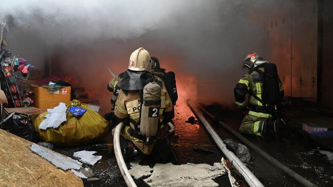 Сотрудники пожарной службы МЧС РФ во время тушения пожара в павильоне с пиротехникой в Ростове-на-Дону