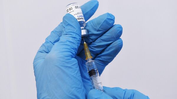 Медицинская сестра набирает в шприц вакцину Гам-КОВИД-Вак 