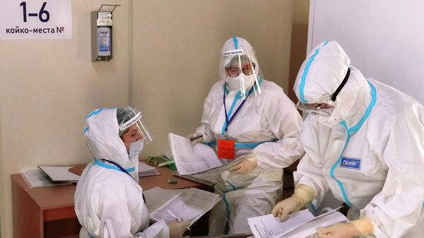 Медицинские работники на медицинском посту во временном госпитале для больных COVID-19, организованном в выставочном комплексе Ленэкспо
