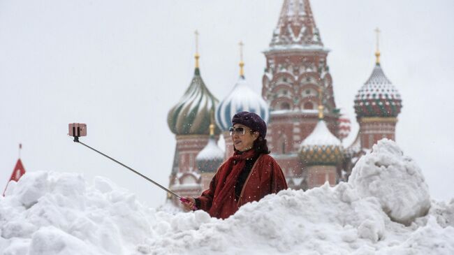 Женщина фотографируется у храма Василия Блаженного на Красной площади