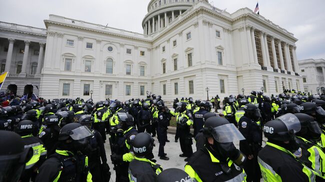 Сотрудники полиции во время акции протеста сторонников бывшего президента США Дональда Трампа у здания конгресса в Вашингтоне