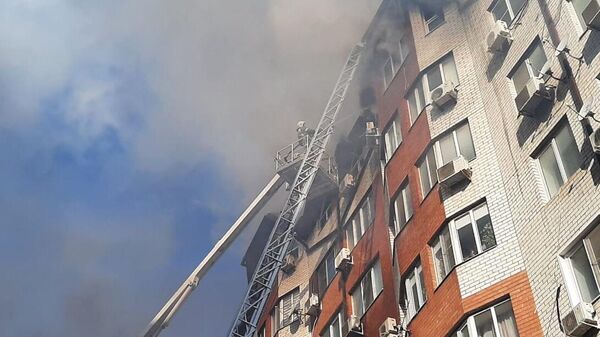 Сотрудники противопожарной службы тушат пожар в восьмиэтажном жилом доме в Анапе