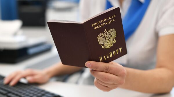 Сотрудник пенсионного фонда держит в руках российский паспорт